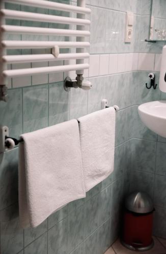 a bathroom with white towels hanging on a rack at Agroturystyka Pod Modrzewiami in Nowy Tomyśl