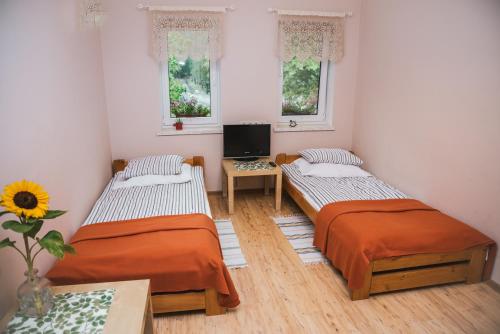 Ένα ή περισσότερα κρεβάτια σε δωμάτιο στο Agroturystyka Pod Modrzewiami