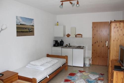 Kleines Zimmer mit einem Bett und einer Küche in der Unterkunft Königs Wusterhausen, Grünheide, Senzig in Königs Wusterhausen