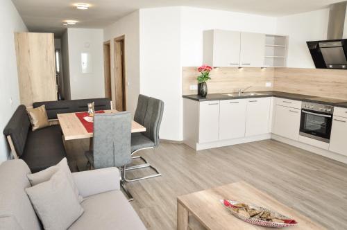 a kitchen and living room with a couch and a table at apart-wolf-arlberg in Warth am Arlberg