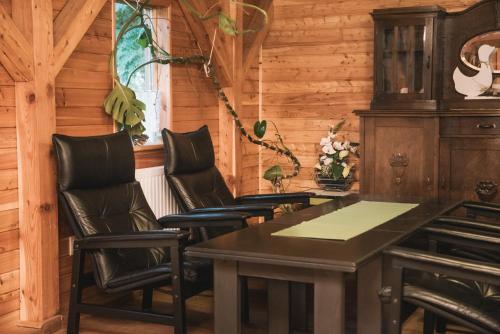 a dining room with leather chairs and a table at Agroturystyka Pod Modrzewiami in Nowy Tomyśl