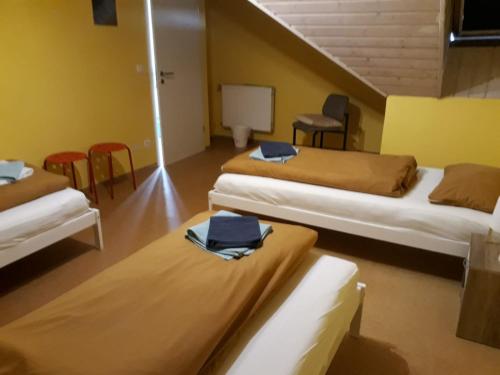 a room with three beds and chairs in it at Gästehaus GL in Ellwangen