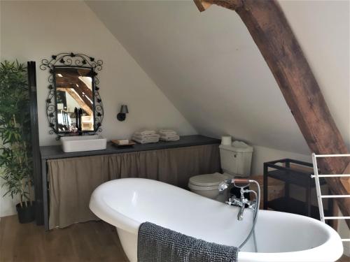 - Baño con bañera blanca en el ático en Domaine LVD avec SPA, bois et rivière privée, en La Bloutière