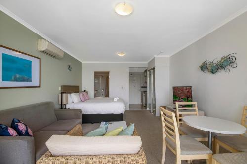a living room with a couch and a bed at Ettalong Beach Luxury Apartments in Ettalong Beach