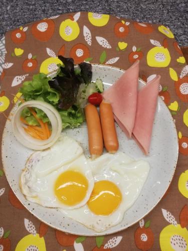 een bord met eieren en groenten op tafel bij Nuan Boutique Hotel in Chiang Mai