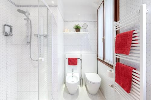 La salle de bains blanche est pourvue d'une douche et de toilettes. dans l'établissement Most convenient apartment in Venice, à Venise