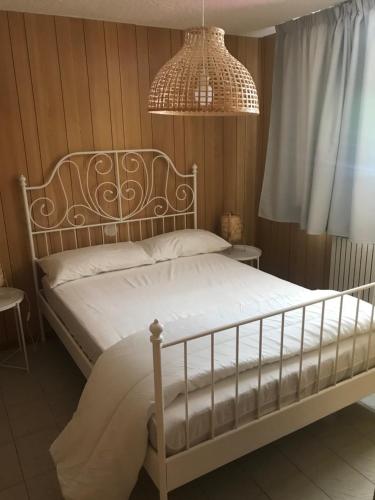 - une chambre avec un lit blanc et un lustre dans l'établissement LE VOLPI, à Mezzana