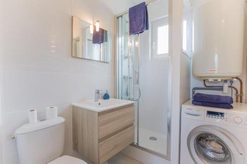 ein Badezimmer mit einem Waschbecken und einer Waschmaschine in der Unterkunft T2 4pers royan centre proche marché / 10mn plage in Royan