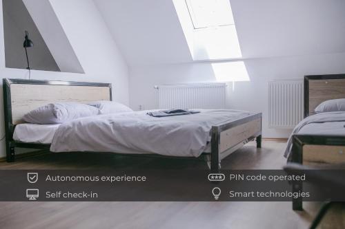 um quarto com uma cama grande e lençóis brancos em Schöndorf Hostel - virtual reception em Bratislava