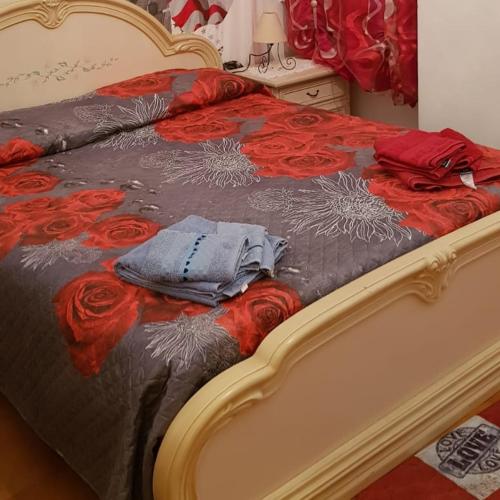 un letto con un piumone rosso e nero con rose di Casa Leida a Bordighera