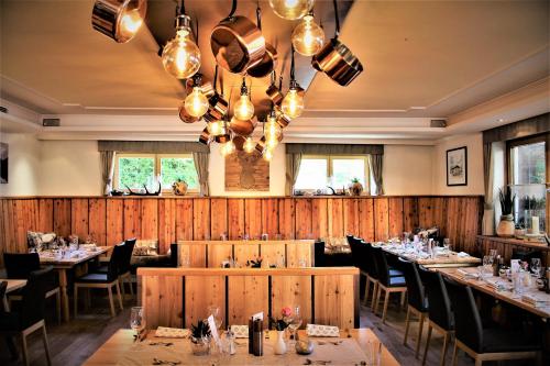 a dining room with tables and chairs and lights at moser-HOCHKÖNIG Genuss Wirtshaus Hotel in Maria Alm am Steinernen Meer