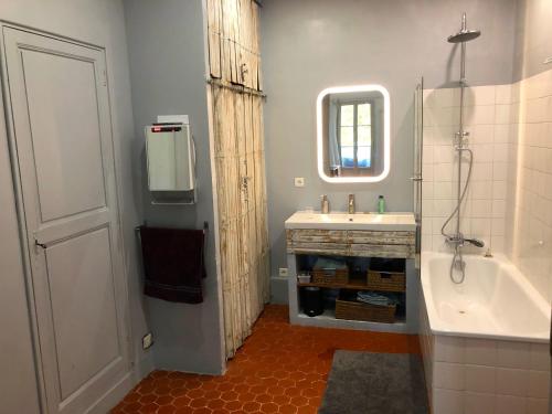une salle de bain avec une baignoire, un lavabo et un miroir dans l'établissement Beau 3 pièces 83 m2 au coeur du centre historique d'Aix en Provence, à Aix-en-Provence