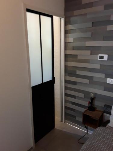 eine Tür in einem Zimmer mit gestreifter Wand in der Unterkunft Joli 2 pièces esprit loft moderne in Pau