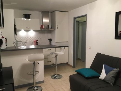 un salon avec un canapé et une cuisine dans l'établissement T2 Rez de jardin 300m Plage de Beaucours Sanary sur Mer, à Sanary-sur-Mer