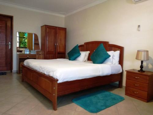 a bedroom with a large bed with blue pillows at Biyem Hotel in Kampala