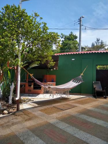 a hammock in a yard next to a green building at APARTAHOTEL TAYAMBE in La Mesa