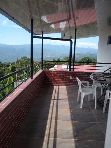 a balcony with tables and chairs and a view at APARTAHOTEL TAYAMBE in La Mesa