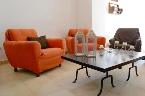 two orange chairs and a coffee table in a living room at Tenuta Afra in Squinzano