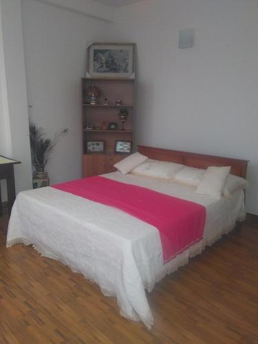 a bedroom with a bed with a red and white blanket at VILLA ARIANNA in Wattala