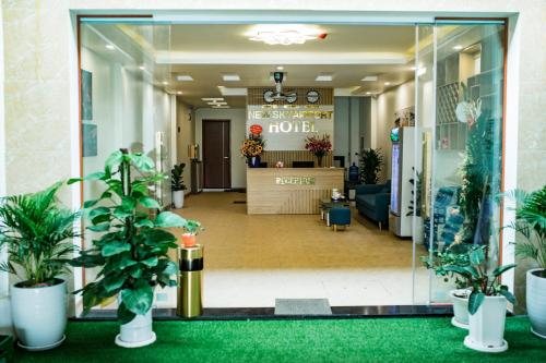 una hall di un hotel con piante in vaso di New Sky Airport Hotel a Noi Bai