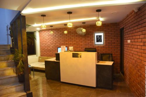 an office with a brick wall and a reception desk at HOTEL RAJPATH INN in Mehsāna