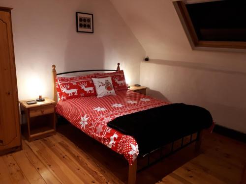 une chambre avec un lit avec une couette rouge dans l'établissement Gite du Sorbier, à Le Chalard