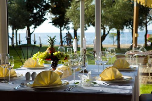 a table with plates and glasses and flowers on it at Residence Umag Plava Laguna in Umag