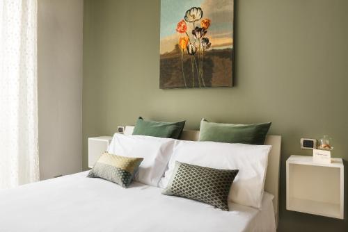1 dormitorio con 1 cama con sábanas y almohadas blancas en B&B Mazzini15, en Novara