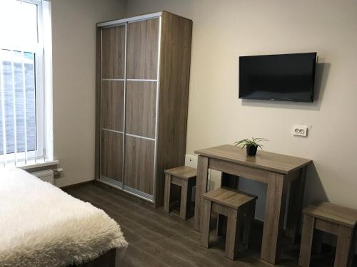 a bedroom with a bed and a tv on a wall at вулиця 8-го Березня Апартаменты in Myrhorod