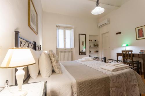Datini Apartment في براتو: غرفة نوم بسريرين وطاولة بها مصباح