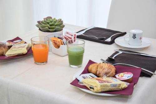 a table with two glasses of juice and a plate of food at Hotel Kennedy in Naples