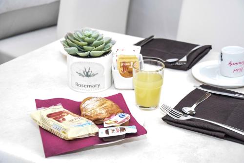 a table with a plate of food and a glass of orange juice at Hotel Kennedy in Naples