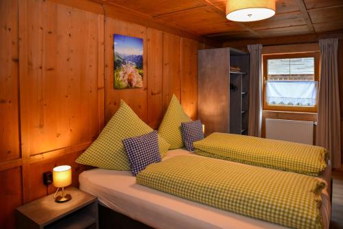 Habitación con 2 camas y paredes revestidas de madera. en Ferienwohnungen Momo en Elbigenalp