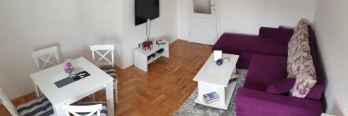 a living room with a purple couch and a table at Apartment Marko in Trebinje