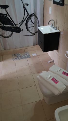 a bathroom with a bike hanging above a toilet and a sink at Antigua Fonda Duplex Studio in Concepción del Uruguay
