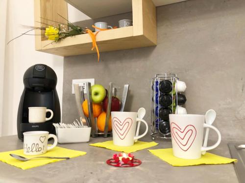 a kitchen counter with two mugs on top of it at Suite Mazzini con piscina in Ostuni