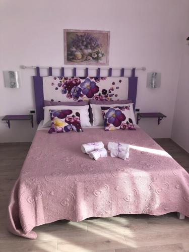 a pink bed with two towels on top of it at Casa Violet per Civita in Bagnoregio