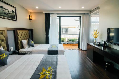 a hotel room with two beds and a television at Topone Halong Hotel in Ha Long