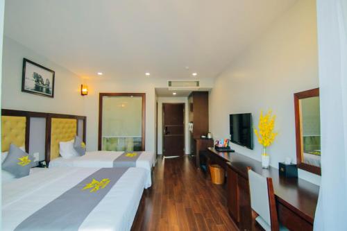 Habitación de hotel con 2 camas y TV de pantalla plana. en Topone Halong Hotel, en Ha Long