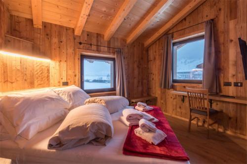 ein Schlafzimmer mit einem Bett in einem Holzzimmer in der Unterkunft Agriturismo La Poina in Livigno