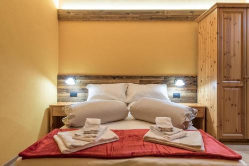 a bed with pillows and pillows on it at Agriturismo La Poina in Livigno