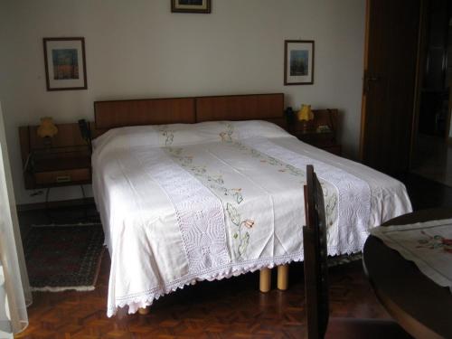 a bedroom with a bed with a white blanket on it at La casa dei pini in Malnate