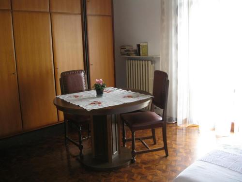 a dining room table with chairs and a table with flowers on it at La casa dei pini in Malnate