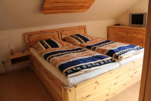 1 Schlafzimmer mit 2 Betten und einem Bettrahmen aus Holz in der Unterkunft Ferienhaus Erika in Graupa
