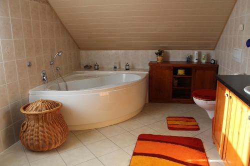 ein großes Bad mit einer Badewanne und einem WC in der Unterkunft Ferienhaus Erika in Graupa