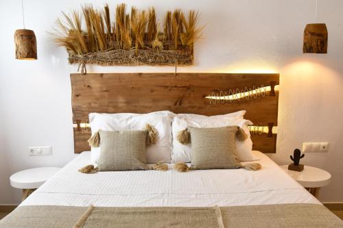 a bedroom with a large bed with white sheets and pillows at Angelos Design Suites in Patitiri
