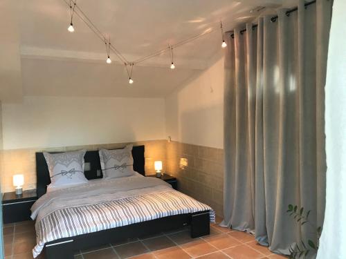 - une chambre avec un lit et 2 lampes et rideaux dans l'établissement Suite luxe vue sur piscine et parc, à Miramas