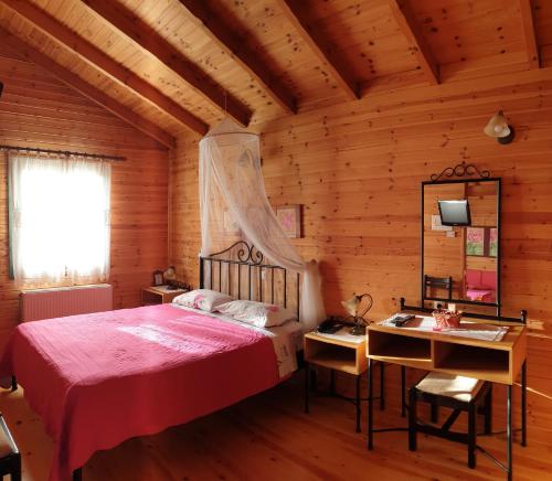 a bedroom with a bed and a desk and a mirror at Alagonia Country Homes in Alagonía