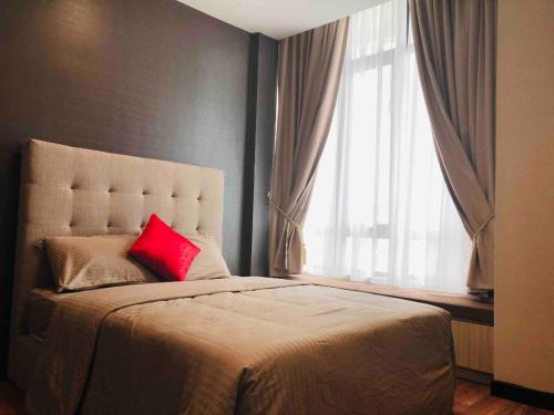 - une chambre avec un oreiller rouge sur un lit et une fenêtre dans l'établissement Shaftsbury Putrajaya 2BILIK by CikYatie, à Putrajaya