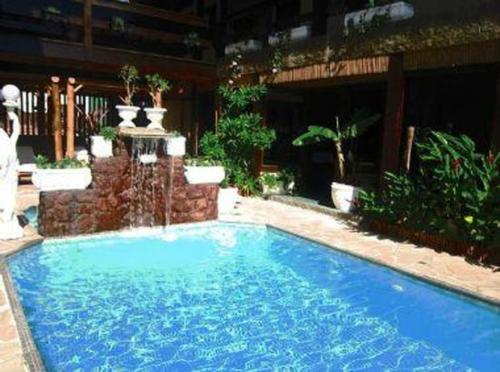 a large blue swimming pool in front of a building at Hotel Pousada Laje de Itauna in Saquarema